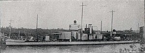 a black and white photograph of a low profile vessel on a river