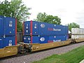 A portion of a 5-unit container well car in a passing Union Pacific train at Rochelle Railroad Park