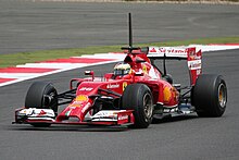 Photographie d'une monoplace de Formule 1 rouge, vue de trois-quarts.