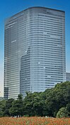 Ground-level view of a thin high-rises's curved, glass facade