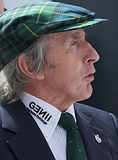 Photo de profil gauche de Jackie Stewart, coiffé d'un béret vert