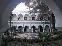 Building with multiple arches, and a fountain in the center of its courtyard