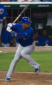 Un joueur de baseball à la frappe, bâton en mains.