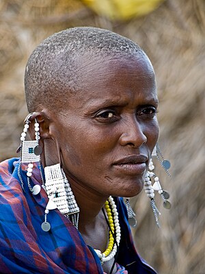 אישה משבט המסאים, עם תכשיטים מסורתיים של בני השבט. נשים מסאיות קלות לזיהוי בזכות ראשן המגולח, וחרוזים השזורים על בגדיהן. כמו כן, נוהגות הנשים לעקור את אחת משינהן התחתונות.
