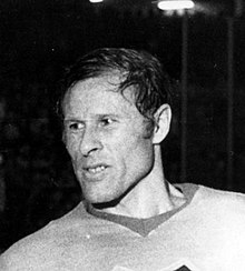 Black and white photo of an adult male wearing a hockey jersey