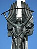 Bronze figure of an angel mounted on a stone column bending a sword