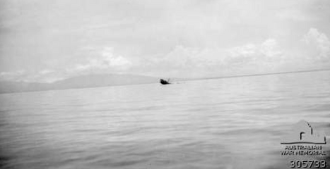 The U.S. Army Transport Jacob settles by the bow with survivors swimming in the water (March 8, 1943)