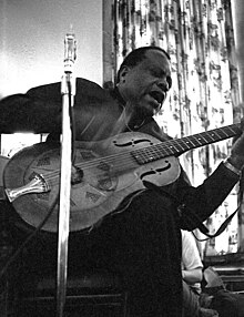 Photo of Bukka White performing with his National steel-bodied guitar, at the University of Chicago Folk Festival, 1968.