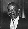 A black-and-white head ean shoulder shoot of a man wearing white shirt and a black tie.