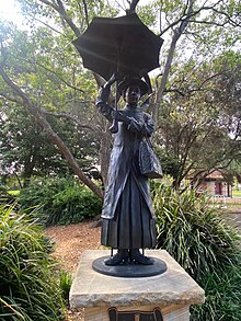 A lifesize cast bronze statue of Mary Poppins holding an umbrella.