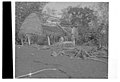 Photo en noir et blanc d'une maison où la moitié de la toiture est absente.