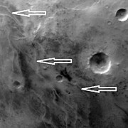 Ridges, believed to be eskers of the Dorsa Argentea Formation, as seen by Mars Global Surveyor wide angle MOC. White arrows point to the ridges.