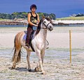 Cavalière de loisir en randonnée sur une plage du Finistère, Bretagne.