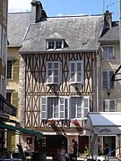 Photographie en couleurs d'une maison à colombages de bois.