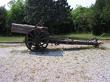 an artillery piece with no gun shield standing on gravel.