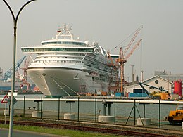 A cruise ship being repaired is photographed in the distance