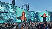 Adele appearing on the blue background of a giant screen