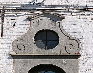 Le fronton à volutes de la porte du corps de logis.