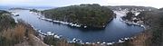 The natural port of Gaios, created by the islet St Nicolas (islet) (center) resembles a fjord. Panoramic view of both entrances: Islet and monastery of Panagia to the North (left) and main settlement to the center and South (right).