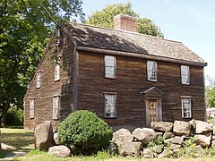 Small wooden house with red-brick chimney in the middle