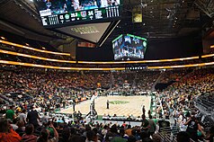 Interior of a basketball arena showing a large crowd in the lower tiers while the upper tiers, ringed by video advertisement boards, is blocked off