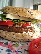 Hamburguesa vegetariana preparada con pan de lino, queso de soja, lechuga, mostaza, tomate y una hamburguesa