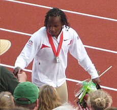 Walter Dix gives an autograph to a fan at the side of the running track