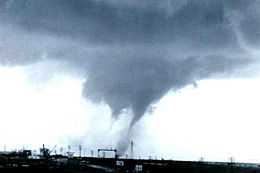 A greyish funnel cloud silhouetted against a pale background