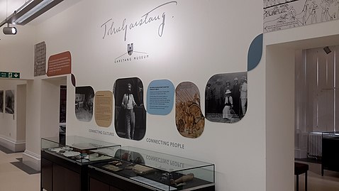 Museum display with artefacts and images relating to John Garstang. A black and white photograph of Garstang is displayed in the centre, under the signature of Garstang and the Garstang Museum logo.