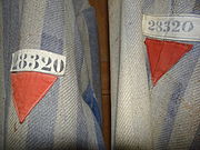 Red emblems of a political enemy on a Dachau detainee's clothing.^