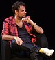 Colour photograph of Richard Bacon sitting on a chair in 2010