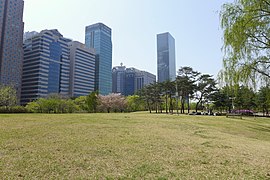 a grassy field in the middle of the park.