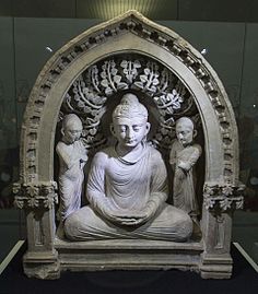 Group of Buddha seated between two monks, with two quasi-Corinthian pilasters that are here because of the influence of Greek culture during the Hellenistic period, 1st-3rd centuries, stone, State Museum of History of Uzbekistan