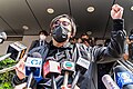 Mike Lam speaking with reporters before entering the police station