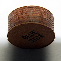 Closeup of a laminated pool cue tip. It consists of multiple layers of vegetable-tanned pig skin.