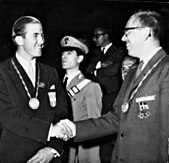 Photographie en noir et blanc de deux jeunes hommes se serrant la main.