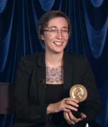 Terrace smiles, holding a golden Peabody Award trophy
