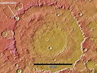 Huygens Crater with circle showing place where carbonate was discovered. This deposit may represent a time when Mars had abundant liquid water on its surface. Scale bar is 259 km long.