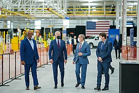 President Joe Biden, Ford CEO Jim Faley, and two other men are seen talking to one another during Bidens visit to the Ford Rouge Electric Vehicle Center on May 18, 2021.