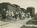 Passengers, leaving the New South Wales Railways carriage on the right side, transferring to a Queensland train on the left at Clapham Junction, Moorooka, probably during WW2