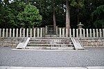 Torii and concrete fence among trees.