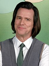 Jim Carrey smirks as he looks towards his left