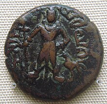 A dark brown coin with two figures on it