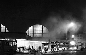火灾期间国王十字站的黑白照片，有滚滚浓烟、车站灯和消防车。