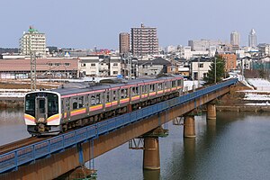 関屋分水橋梁を渡るE129系 （2021年1月 青山駅 - 関屋駅間）