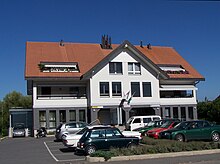 photo de la maison communale de Vully-les-Lacs, comportant la poste et l'administration communale au rez-de-chaussée, des appartements d'habitation aux premier et second étage