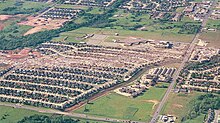 A housing complex, with a large swath of destroyed homes running through the center. Ground scouring is also visible.