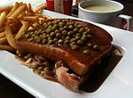 Quebec-style "hot chicken", topped with green peas