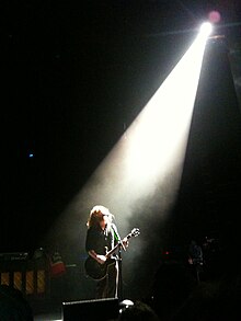 James under a spotlight onstage