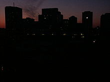 City skyline at dusk with only a very few office building windows lit